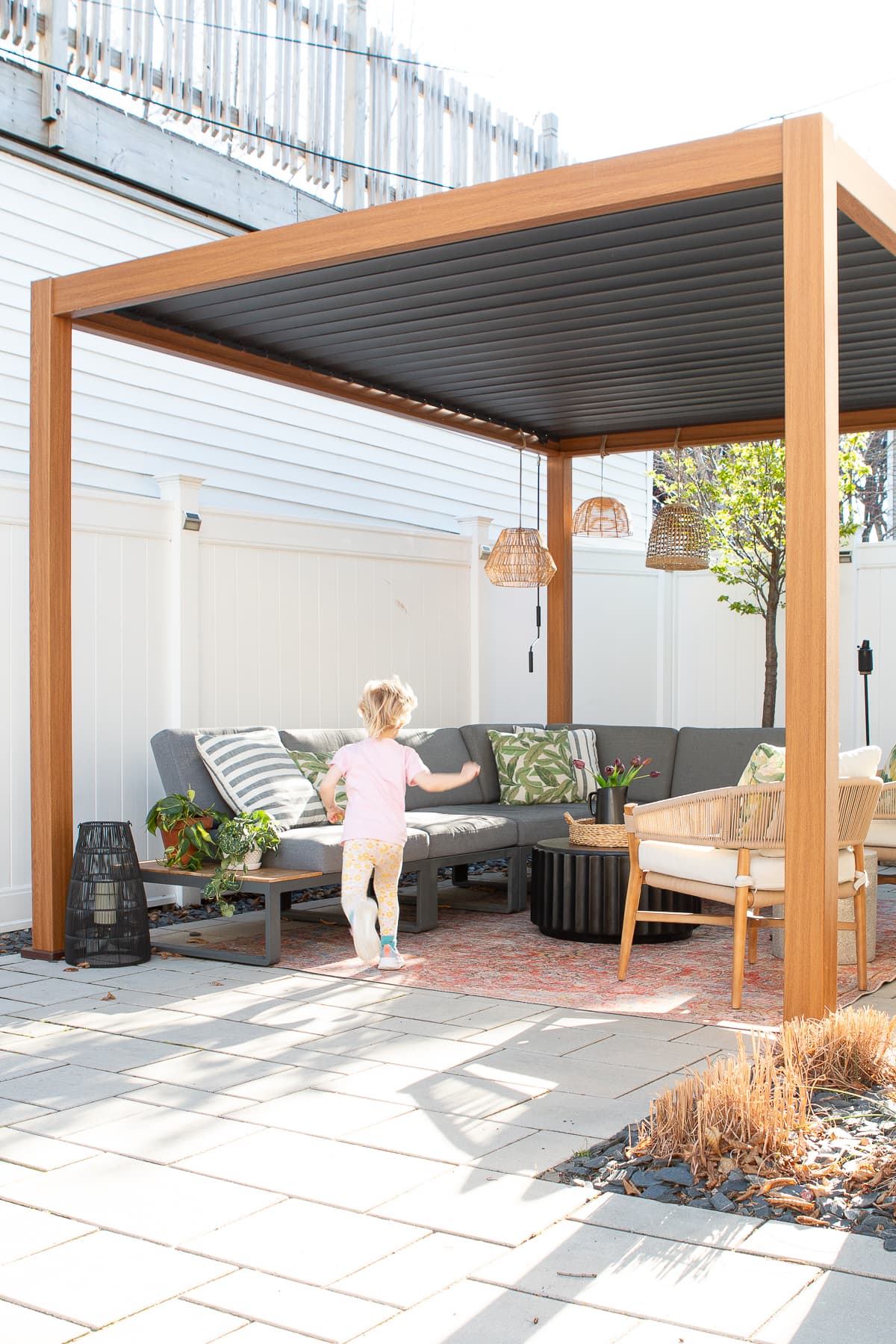 An outdoor space underneath a small backyard pergola